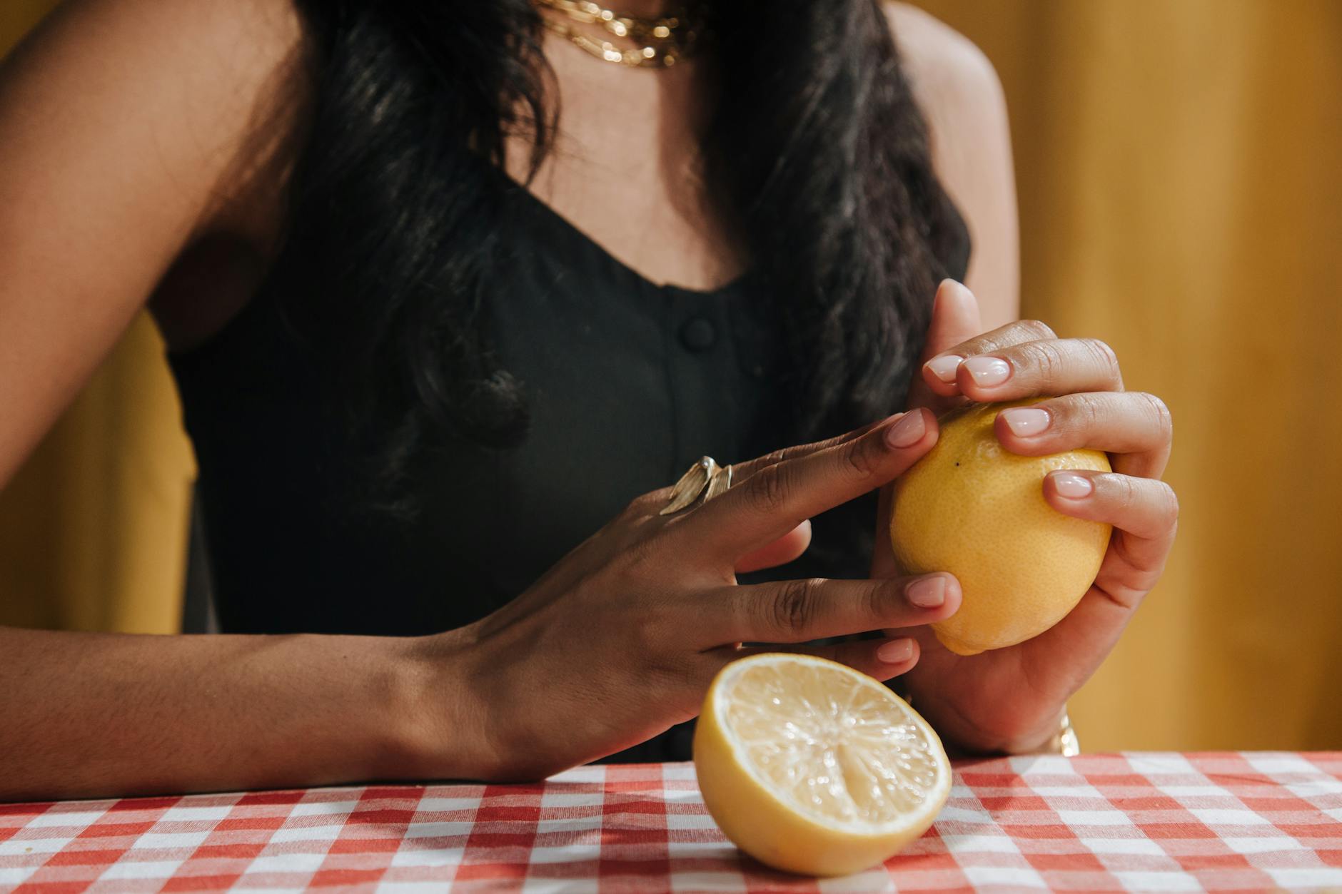 A person holding a fresh lemon, representing the bright, responsive sensation of clitoral pleasure with hormonal awareness